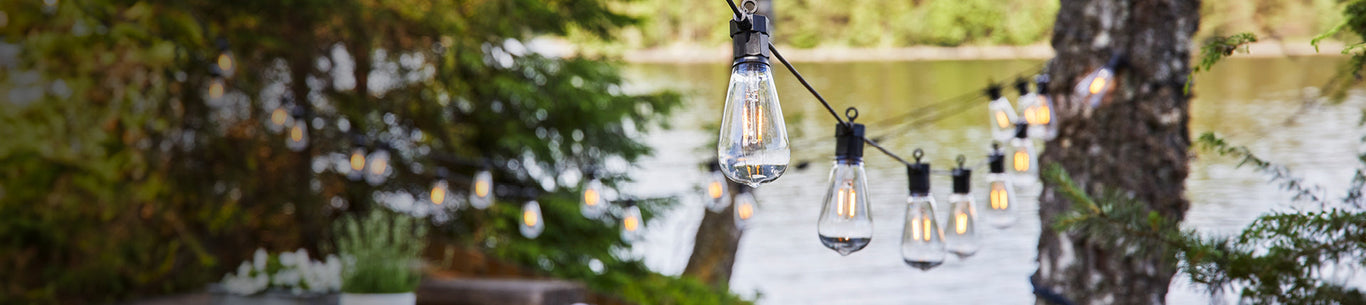 Ljusslingor och partyslingor utomhus mellan träd
